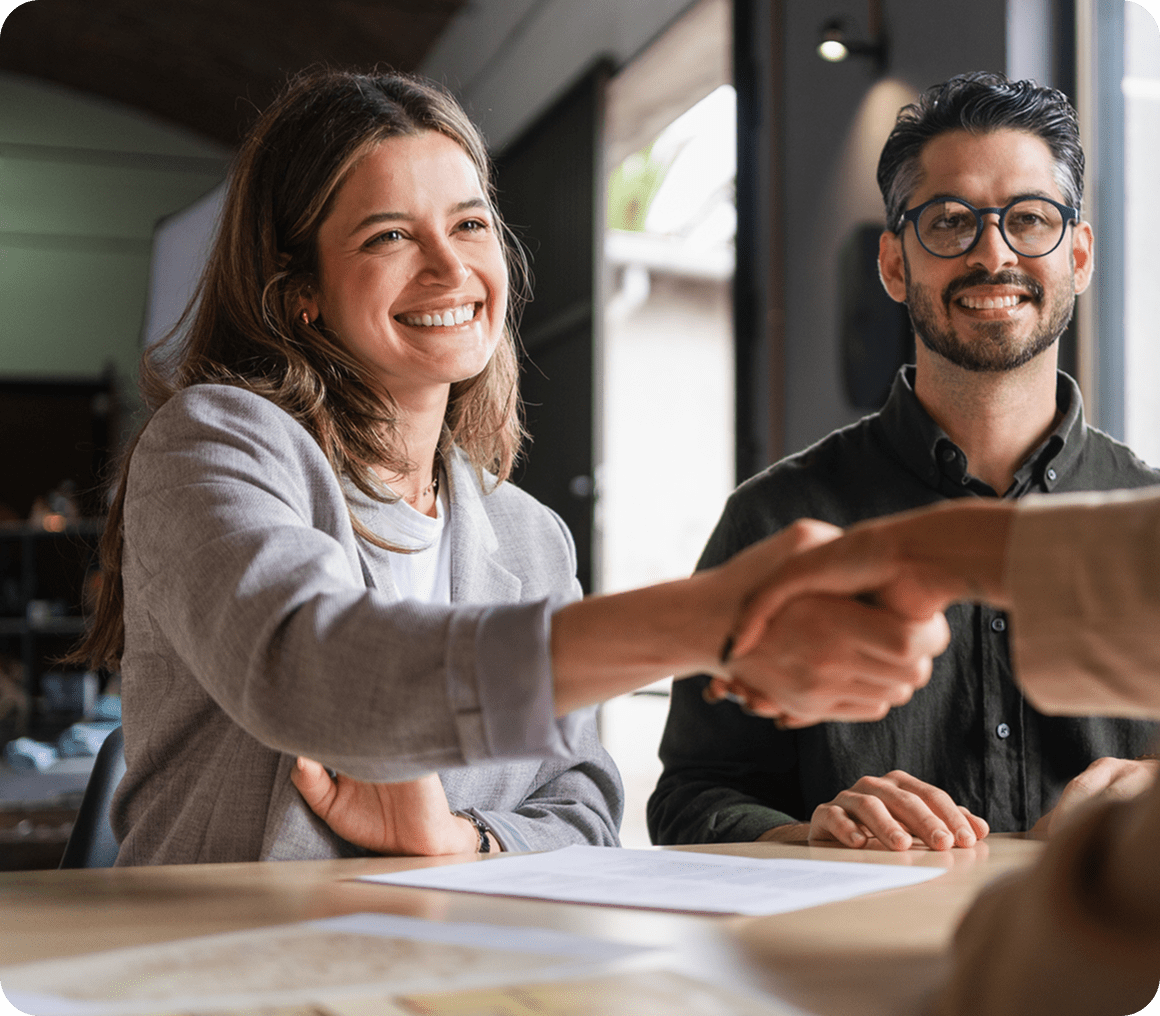 Smiling woman shaking hands at meeting